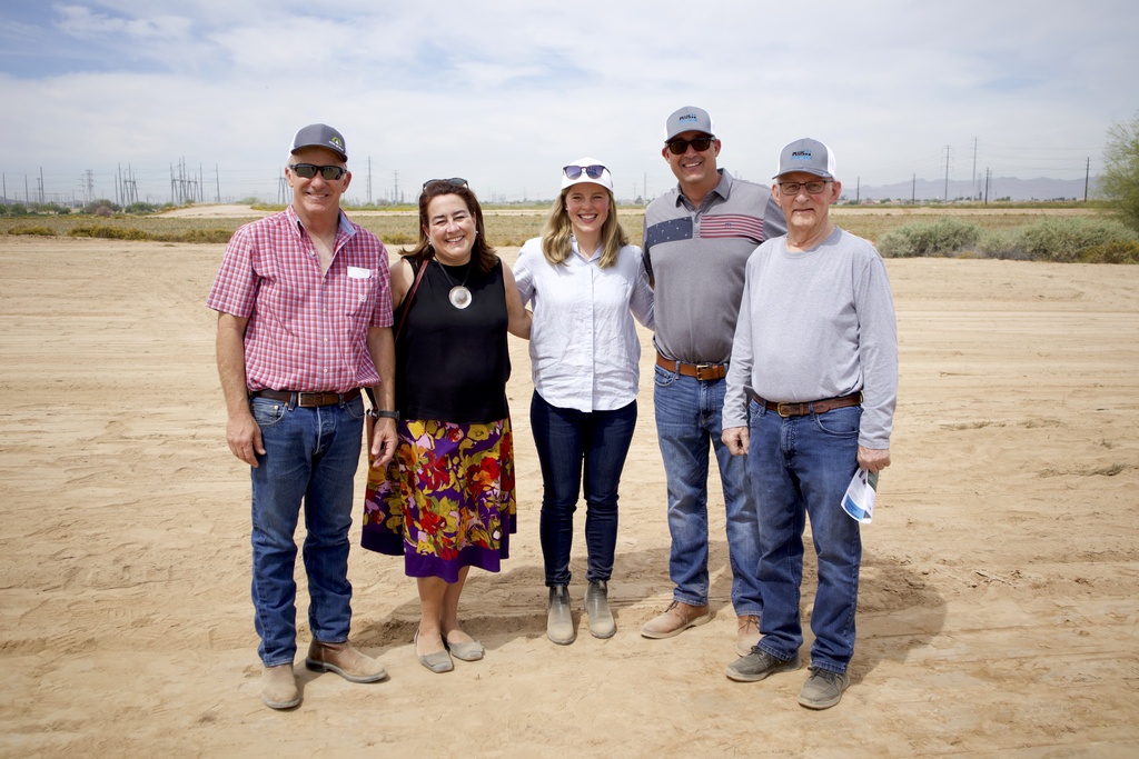 “Corporate team gathered at outdoor groundbreaking event.”