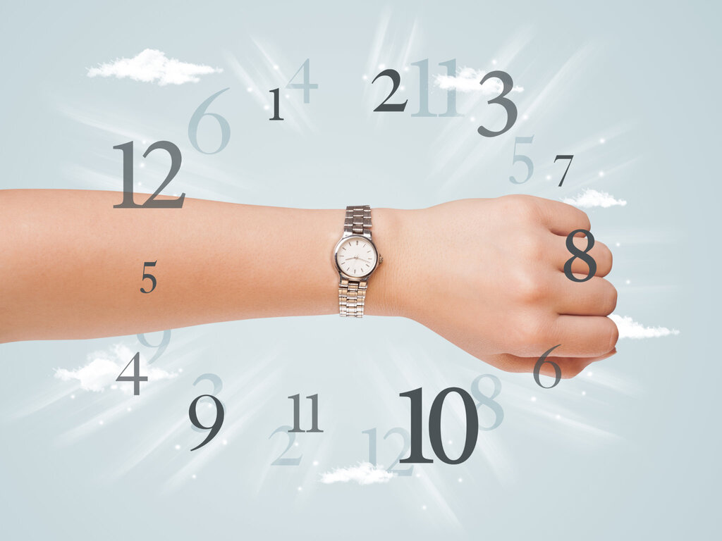 An arm with a watch with the random placement of numbers 1 to 12 overlayed on top