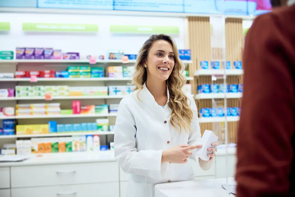 Mitarbeiterin Apotheke präsentiert Kunden Produkt