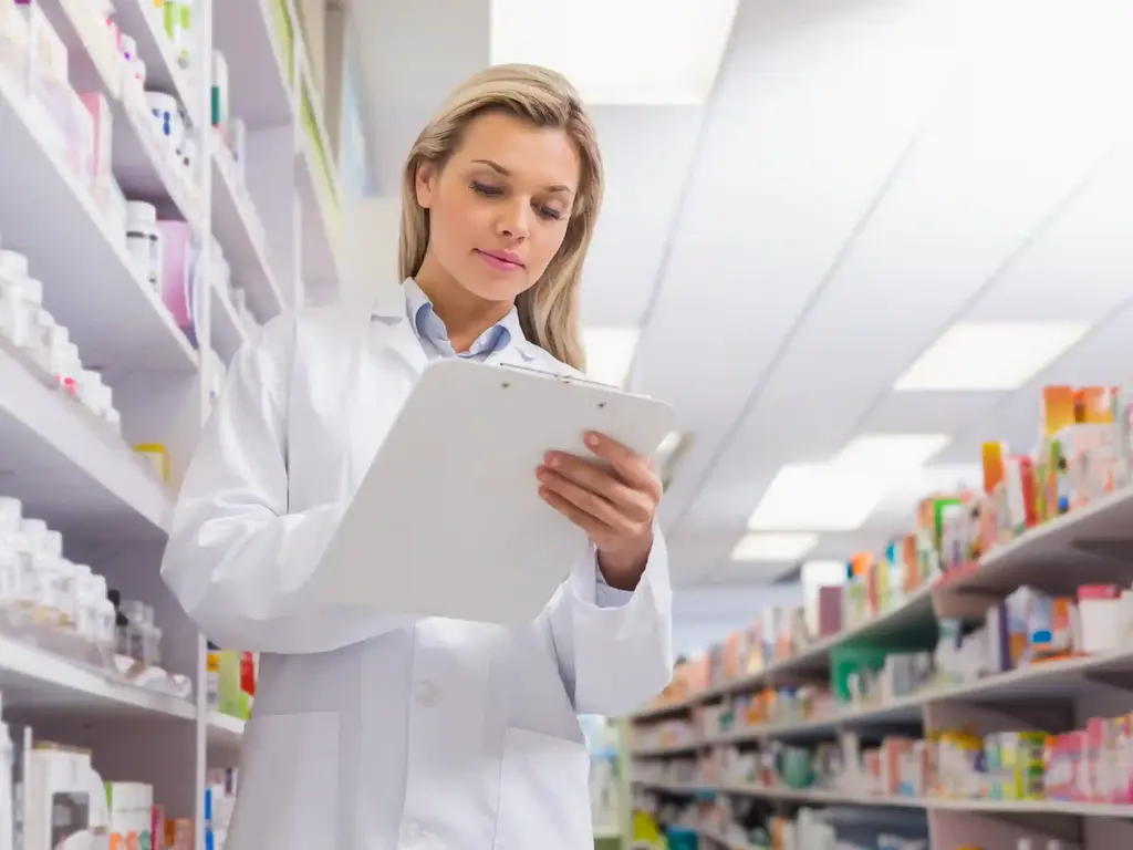 Apothekenmitarbeiterin kontrolliert Klemmbrett mit Liste