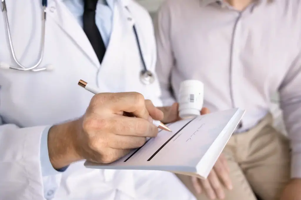 Arzt schreibt mit Kugelschreiber auf Klemmbrett