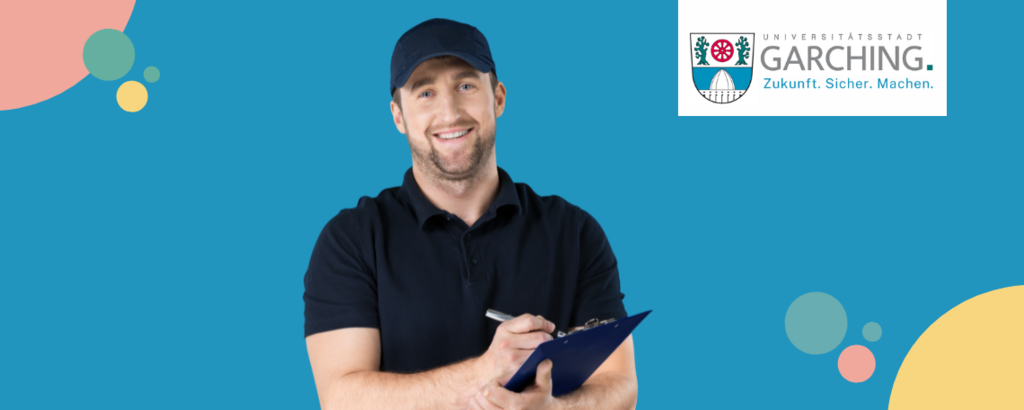 Zwei junge Fachkräfte stehen lächelnd vor dem Logo der Stadt Garching