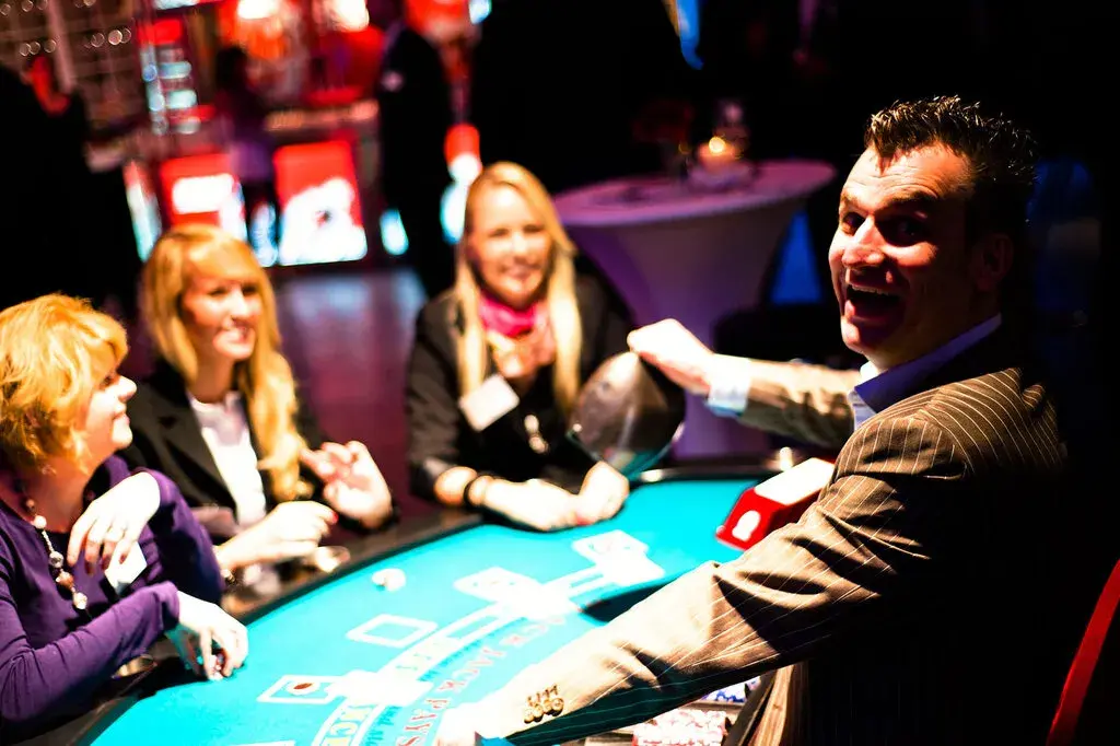 Gäste und Croupier am Black-Jack-Tisch bei einem stimmungsvollen Casino-Event von Rent-A-Casino