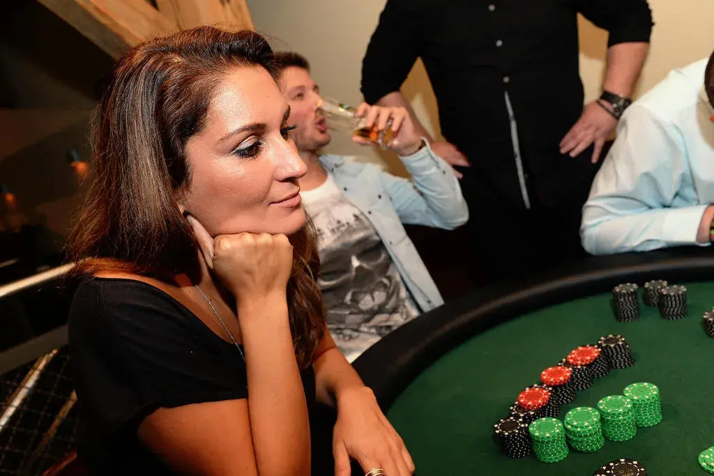 Frau verfolgt nachdenklich das Spielgeschehen am Casino-Tisch bei einem mobilen Casino-Event