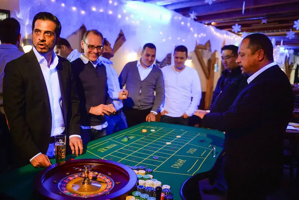 Croupier erklärt Roulette bei einem mobilen Casino Event in Dortmund mit Gästen am Spieltisch