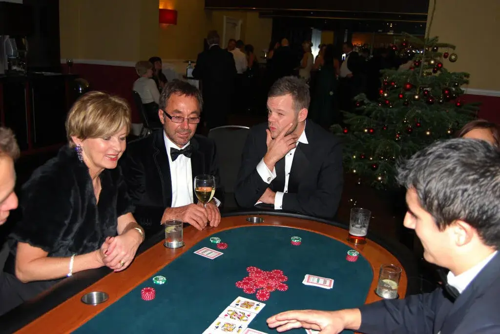 Gäste spielen Poker bei einer weihnachtlichen Firmenfeier