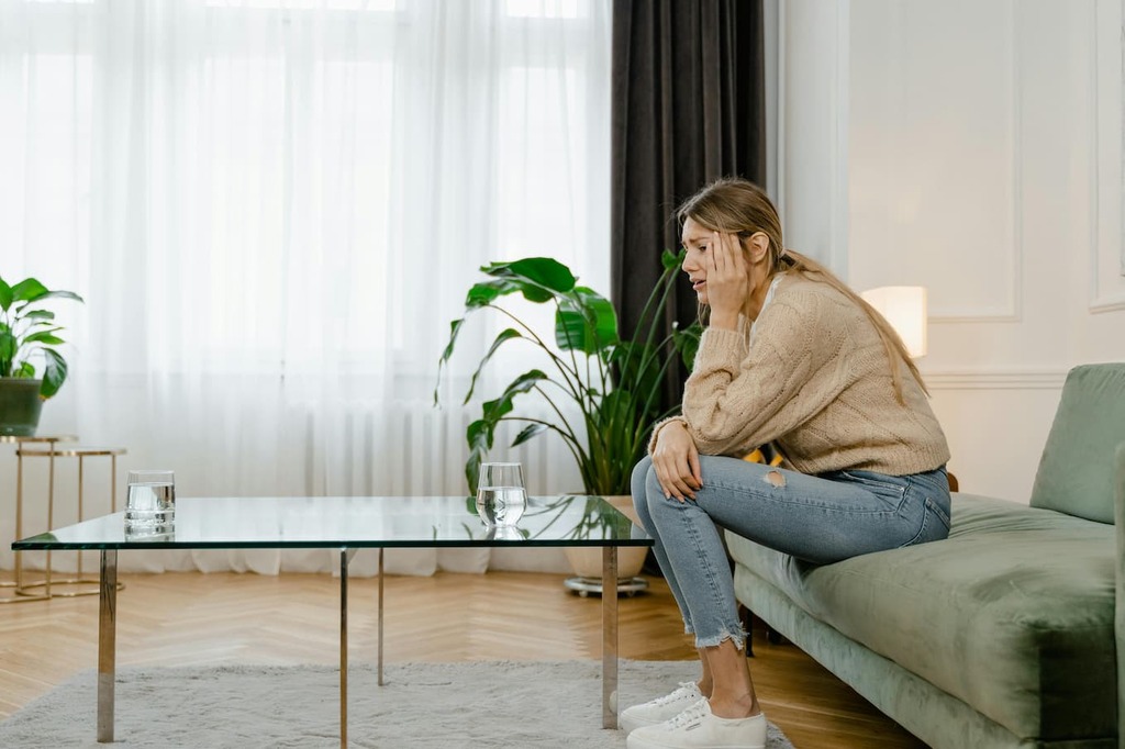 Frau mit Frau mit Panikattacken sitz auf sofa
