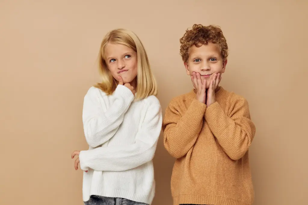 Zwei Kinder vor beiger Wand