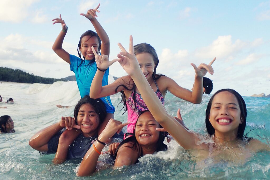 kids playing in the ocean with HMKF