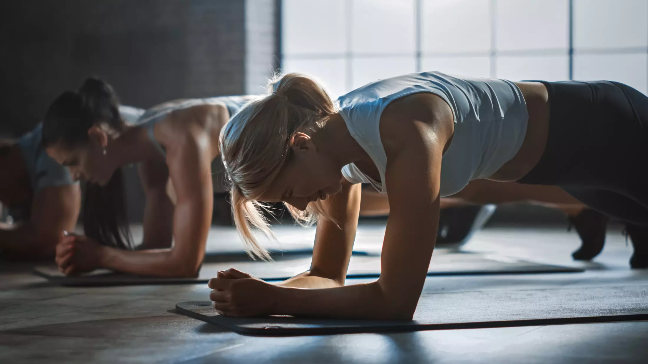 Frauen im Personal Training liegen in der Plank-Position