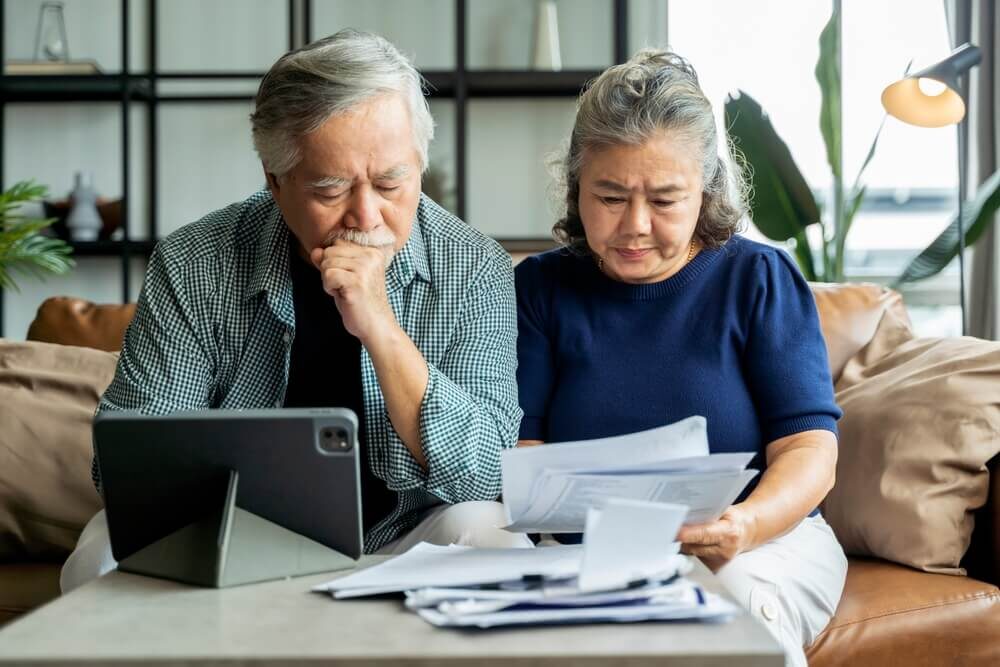 Senior couple reviewing bills, stressed