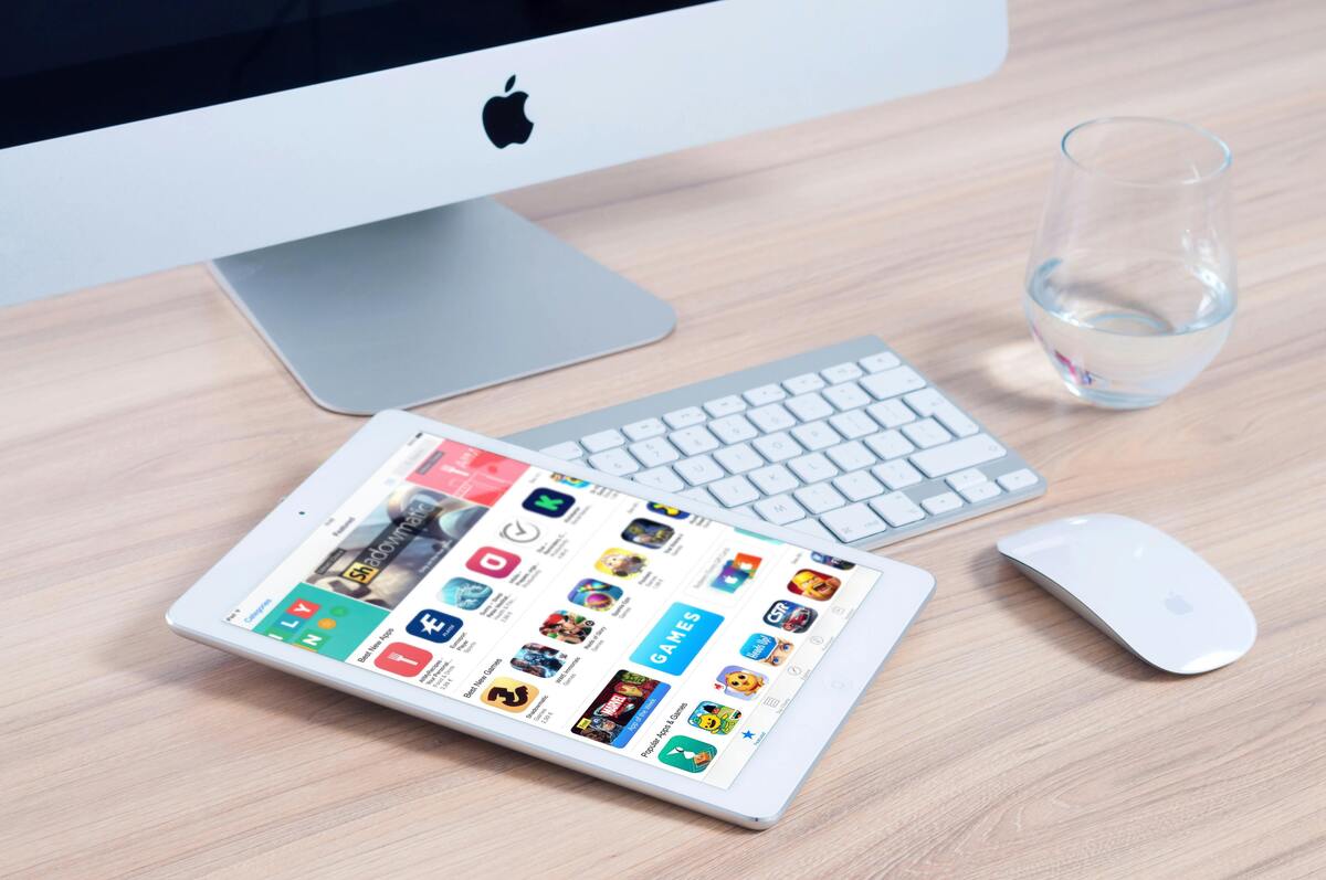 Home office desk with an iMac and an iPad showing apps