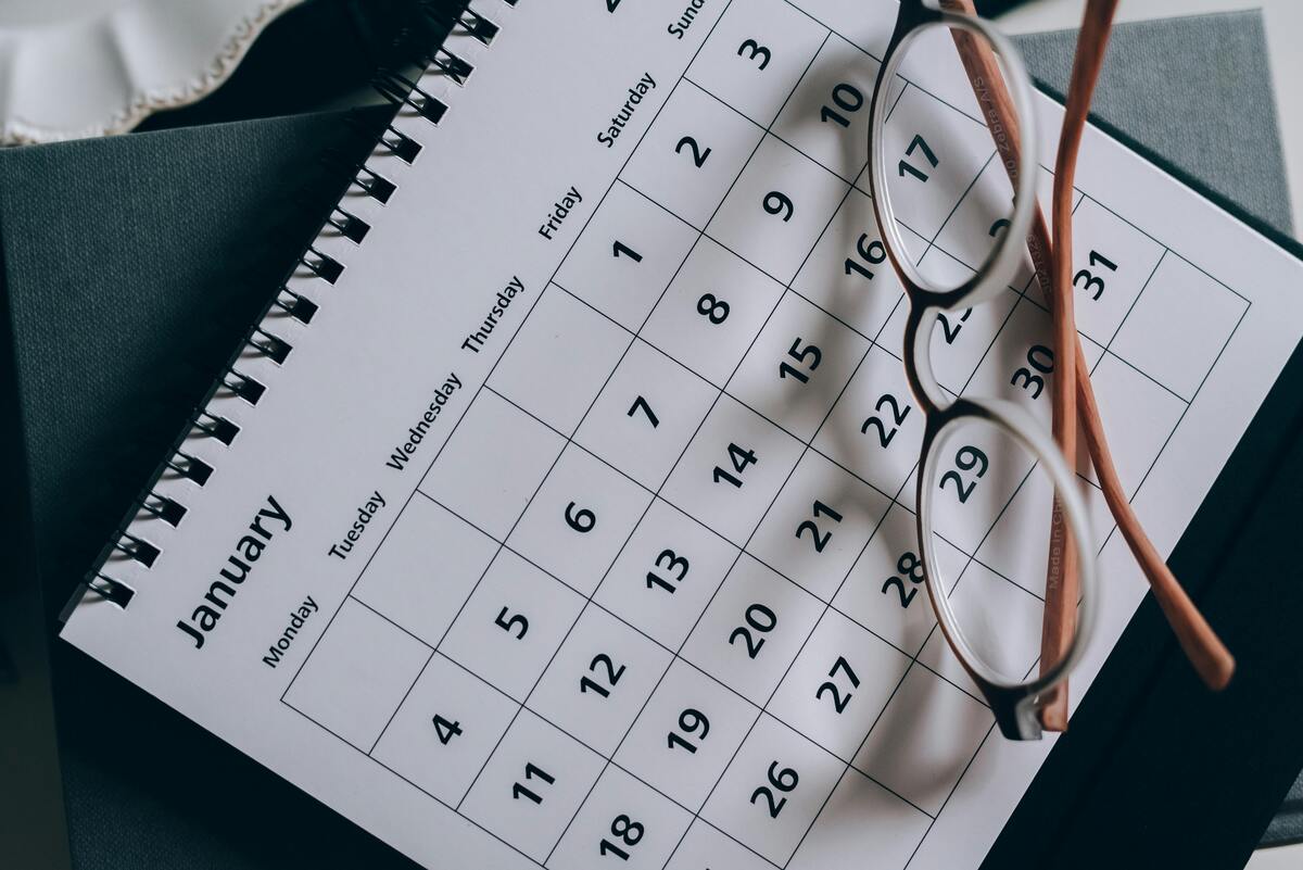 Close-up of a January calendar with eyeglasses resting on a table