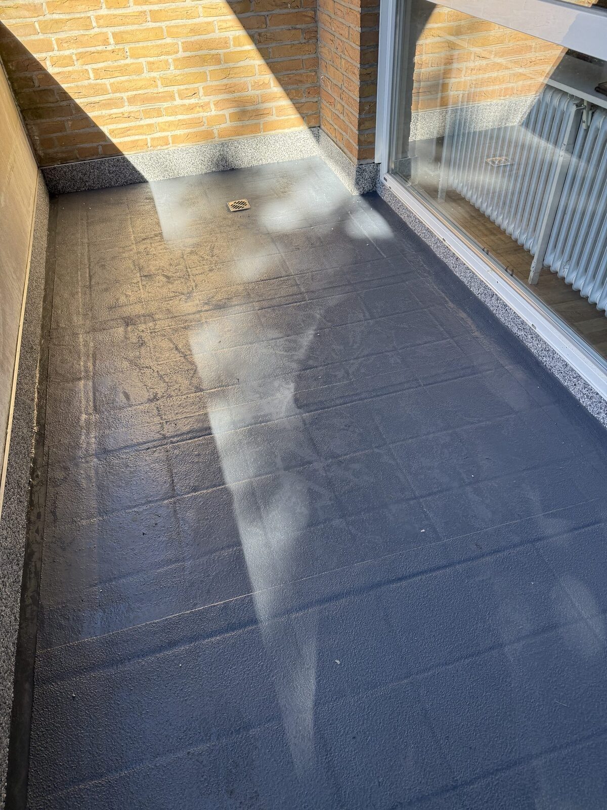 Fertig abgedichteter Balkon mit Ablauf und dunkler Beschichtung