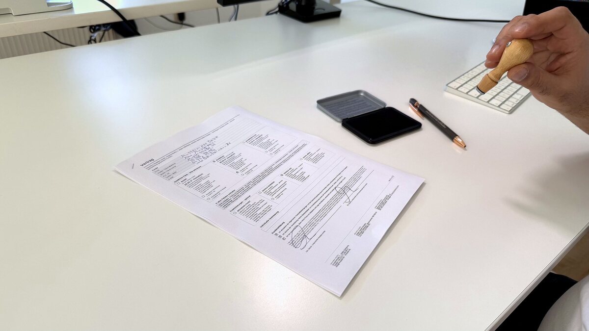 Ausgedruckter Website-Vertrag mit den drei Paketen zum Ankreuzen auf einem Schreibtisch