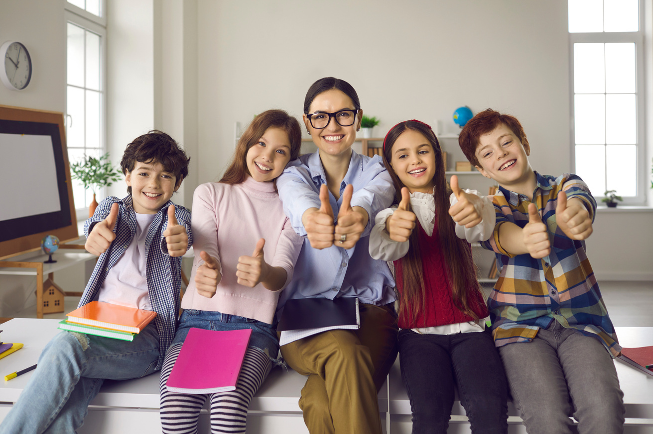 Kinder und erwachsene Person zeigen Daumen hoch