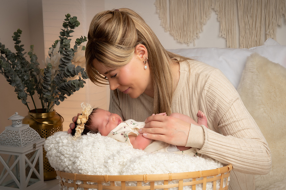 Mutter beugt sich liebevoll zu Baby