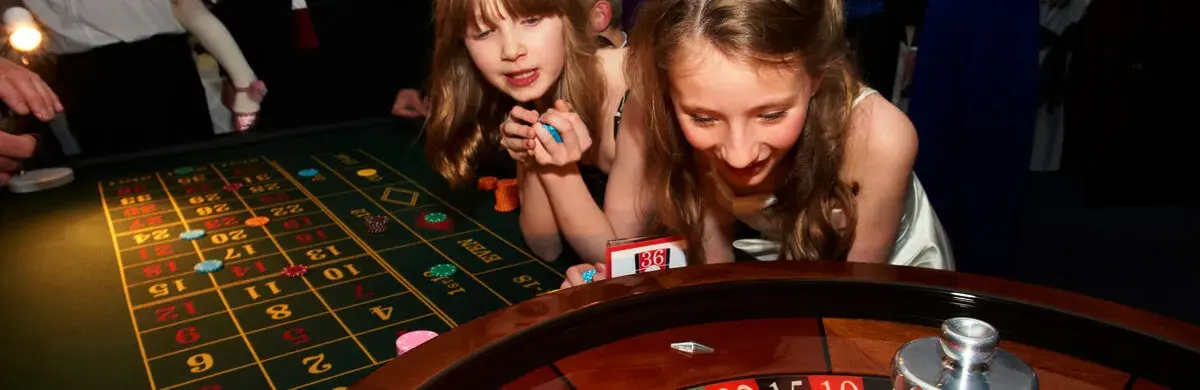 Zwei Mädchen beobachten fasziniert das Roulette-Rad bei einem Casino-Event von Rent-A-Casino