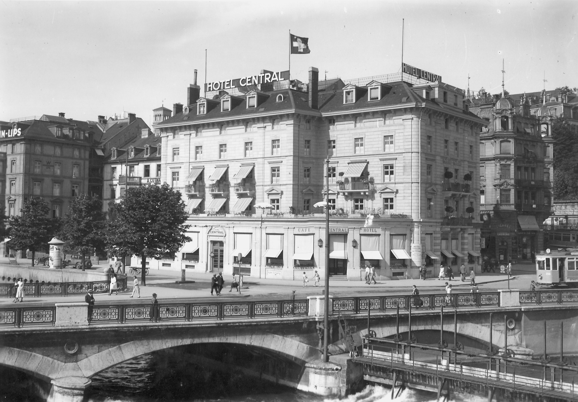 Historic black and white photo of Central Plaza Hotel Zurich (formerly Hotel Central) at Limmat River and Zurich Main Station, dating back over 100 years.