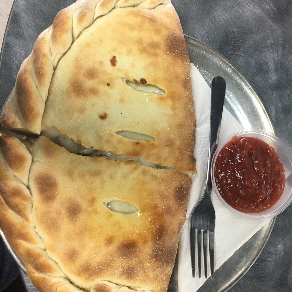 A calzone served with a side of house red sauce. Click this image to see all of our pizza bases and calzone options. 