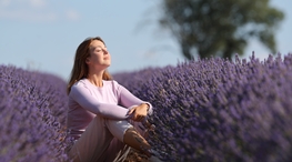 Eine Frau die in einem Lavendelfeld sitzt