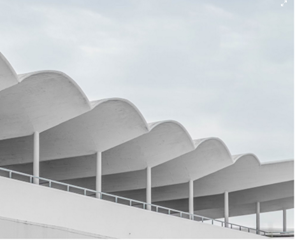 Weiße Dachstruktur mit wellenförmigen Betonelementen auf schlanken Stützen  (Steht für Leichtigkeit und Innovation.)