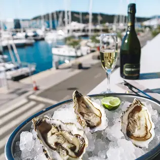 Foto von gekühlten Austern und Champagner vor einem Yachthafen