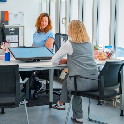 Beratung im Kulturbüro – Zwei Frauen sitzen sich an einem Schreibtisch gegenüber und führen ein Gespräch