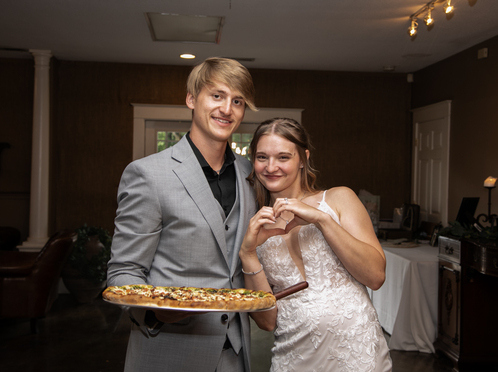 Couple at wedding holding pizza