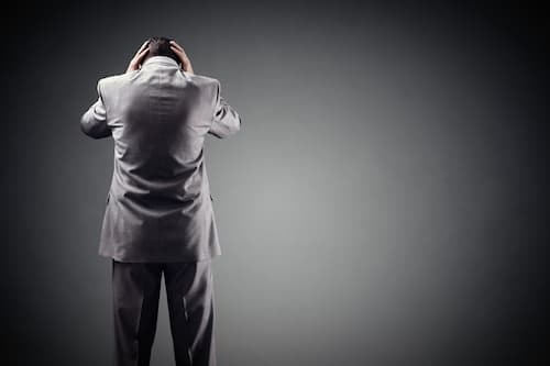 Mann hält sich den Kopf - Symbolbild für Hypnos bei Burnout