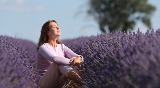 Eine Frau die in einem Lavendelfeld sitzt