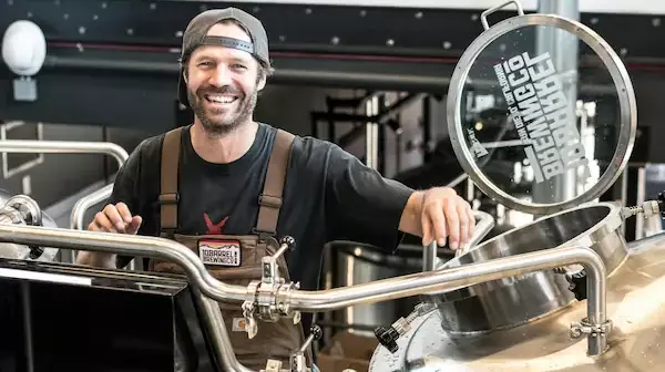 A man working at a brewery smiling