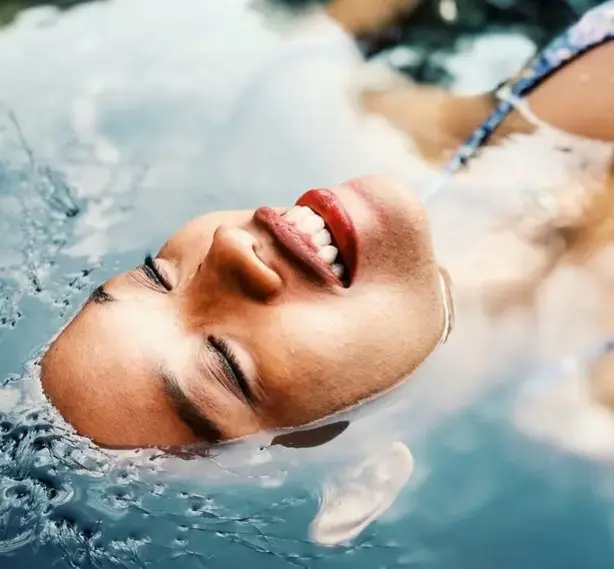 woman laying in spa bath with face above water