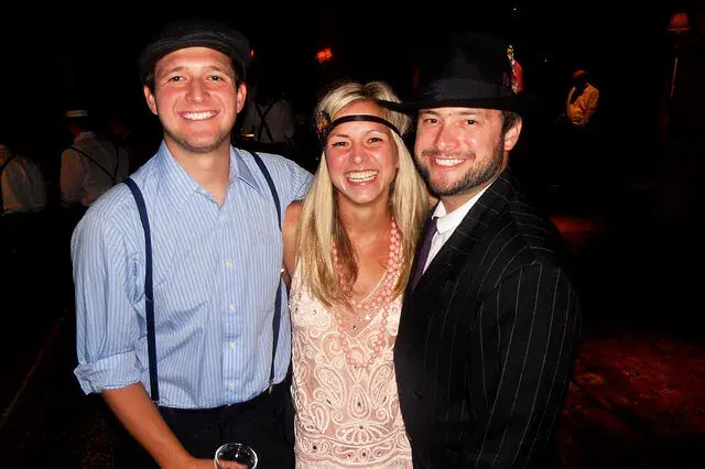 Lächelndes Paar in Gatsby-Kostümen bei einem Mottoabend mit mobilem Casino 