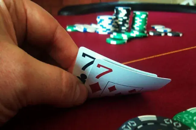 Spielkarten und Casino-Chips auf rotem Spieltisch – hochwertiges Casino-Equipment