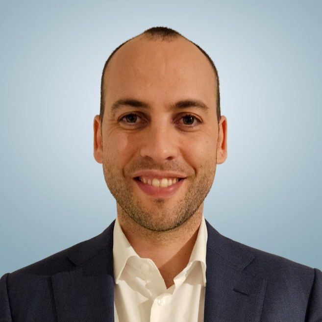 A man in a green jacket is taking a selfie.