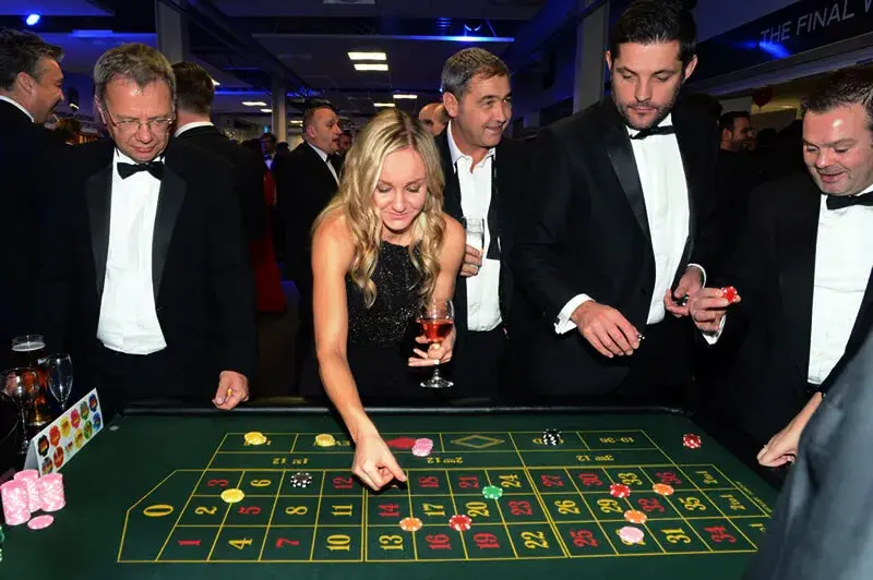 13:25 Frau in Abendkleid setzt Chips am Roulette-Tisch bei einer eleganten Firmenfeier mit mobilem Casino