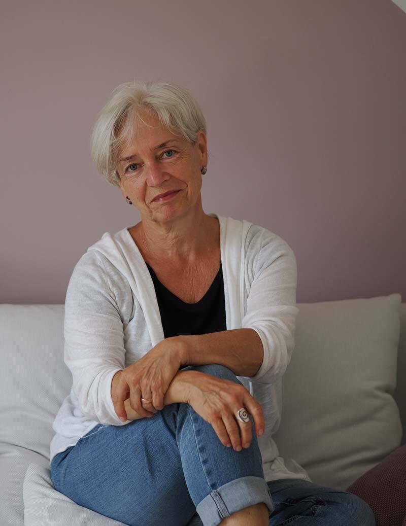Anne Janzen - Tierkommunikatorin und Gestalttherapeutin sitzt auf einem Sofa 