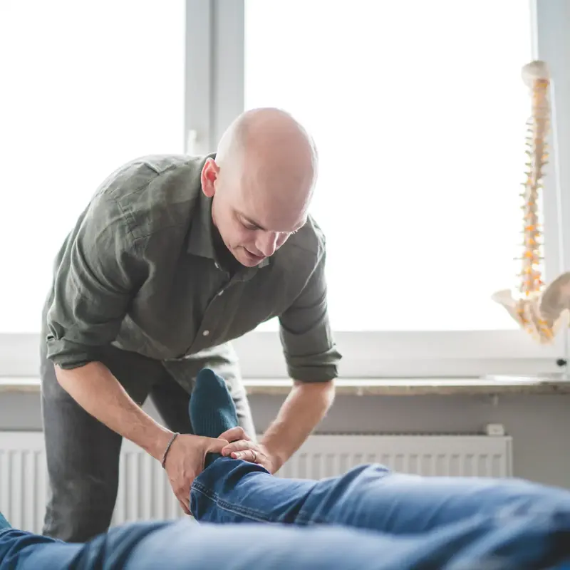 Chiropraktiker Andrew Klinkert behandelt einen Patienten mit Rückenschmerzen in Frankfurt