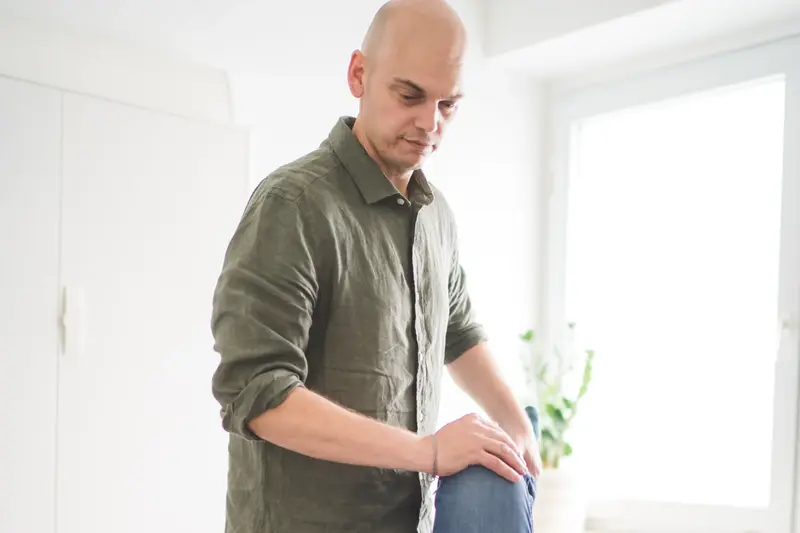 Chiropraktiker Andrew Klinkert untersucht das Knie eines Patienten