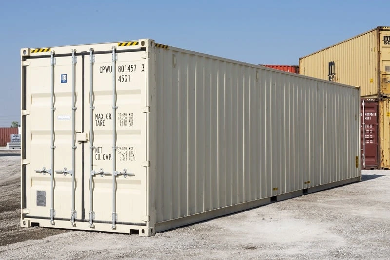 A white 40 HC shipping container sitting in a parking lot.	