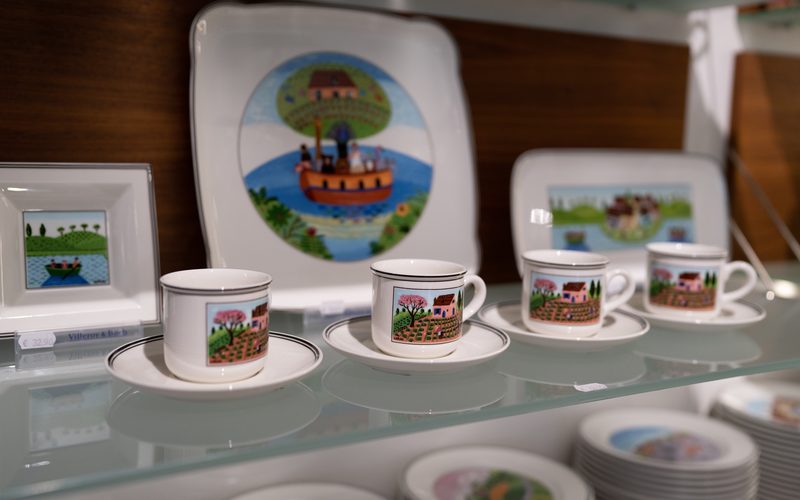 Bunte Kochtöpfe in einem Küchenladen auf Holzregalen