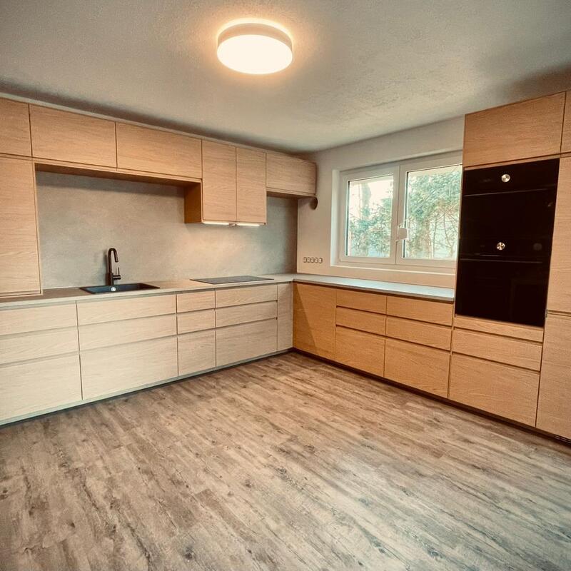 Möbelmontage Berlin – geräumige Eckküche in Creme-Weiß mit Holzakzenten und Einbaugeräten