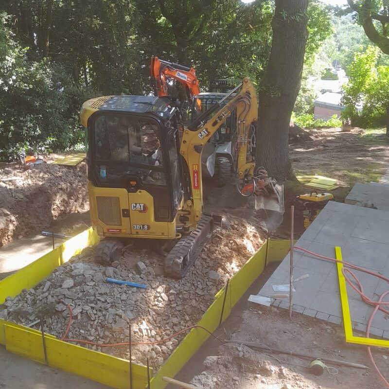 Mini-Bagger bei Pflastervorbereitung im Waldgebiet