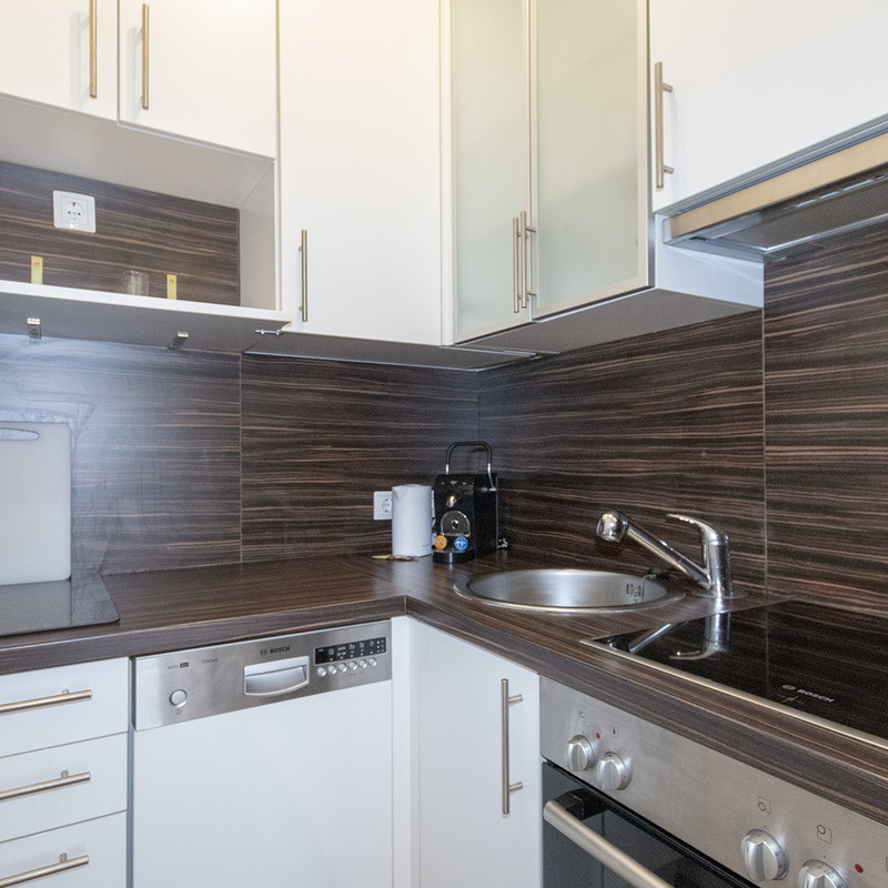 Küche mit Geschirrspüler, Ofen und Geschirr