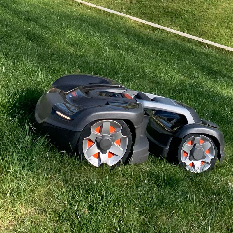 Ein automatischer Rasenmähroboter in Nahaufnahme auf einer frisch gemähten Rasenfläche.