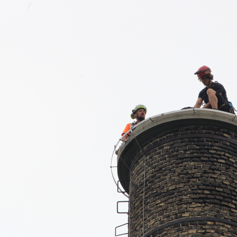 Zwei Personen sitzen auf altem Schornstein