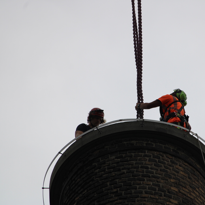 Zwei Arbeiter auf Schornstein mit Kette