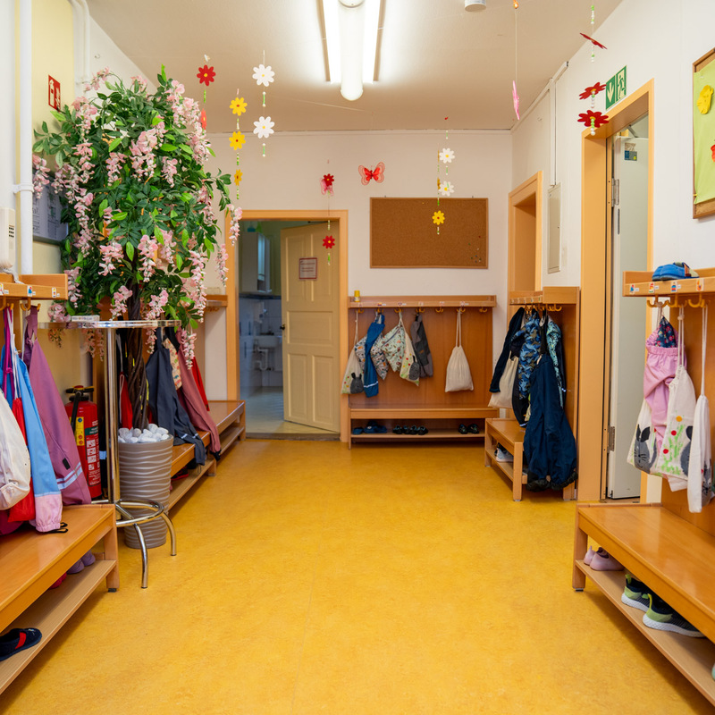 Garderobenbereich im Kindergarten mit bunten Taschen und Dekorationen