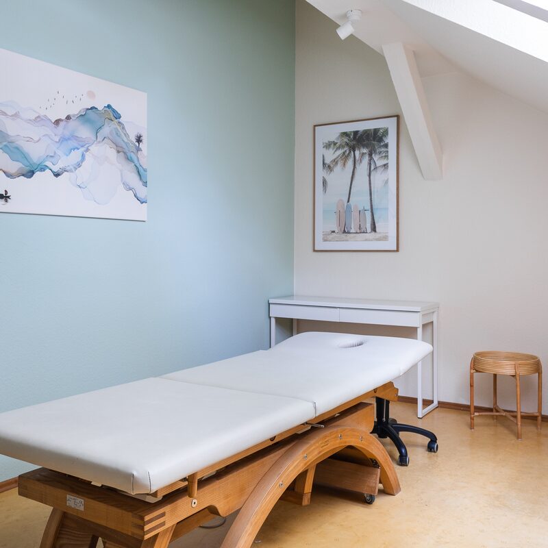 Schlichter Behandlungsraum mit Holzliege